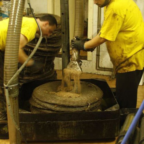 Trabajadores limpiando la pasta de prensado en molino