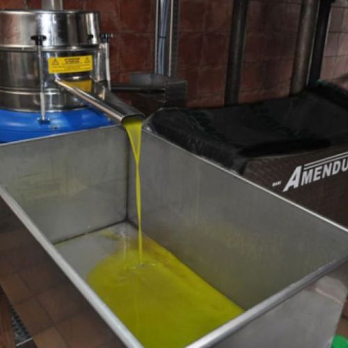 Máquina depositando aceite en cubeta metálica