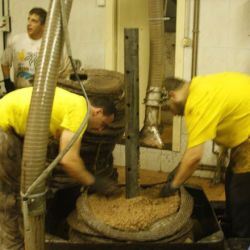 Trabajadores alisando pasta de prensado en molino