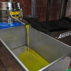 Máquina depositando aceite en cubeta metálica